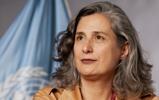 Photo portrait of a woman with grey and the Un flag behind